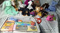 Collection of assorted Ty Beanie Babies plush toys arranged on a surface with visible Ty tags and a portion of the membership bag