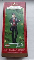 Front of the Hallmark Keepsake ornament box. Red color with a clear window showing the Barbie ornament dressed in black leather style outfit with a Harley-Davidson helmet.