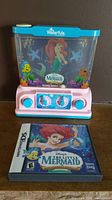 Photo showing the Vintage Waterfuls handheld water game featuring Ariel from The Little Mermaid and Nintendo DS game case for Ariel's Undersea Adventure.