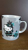 Side view of Hello Kitty Rocks! mug showing Hello Kitty character in rock star outfit and surrounding stars graphic.