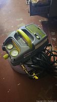 Gray and green Craftsman Evolv air compressor on a floor with visible gauges, power cord, and handle