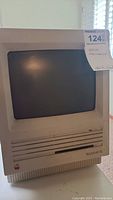 Front view of the Apple Macintosh SE computer showing CRT display and disk drive slot with Mac SE label.