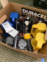 Box filled with various flashlights including Duracell Durabeam Ultra and other colors and sizes.