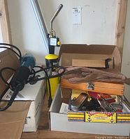 Overview of assortment including Makita tool, blow torch, gloves, and boxes of smaller hand tools.