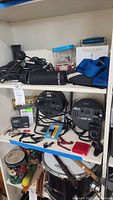 Shelf with audio cables, microphone, blue guitar strap, small music accessories, and Chauvet DJ SlimPAR 56 stage lights