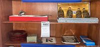 Full shelf view showing snuff bottles in box, wood coasters stacked, stone box, incense burner, and trays