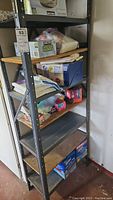 Full view of the metal shelving unit with various storage and packing supplies on shelves.