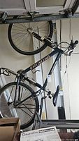 Full left side view of the bike hung vertically showing frame, wheels, saddle and handlebars