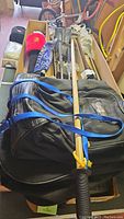 Overview of golf bag packed with clubs and wooden hiking sticks