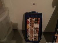 Croquet set in blue carrying bag with clear front showing wooden mallets and balls packed inside.