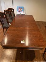 Full top view of the wood dining table showing the smooth polished surface and beveled edges