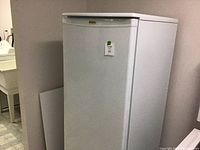 Angled view of the white Kenmore small refrigerator emphasizing its compact size suitable for small spaces.