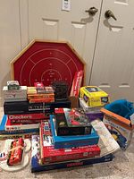 Full view of stacked games with large red octagonal game board behind them.