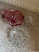 Photo showing all four items: pink glass bowl, clear candy dish, oval serving bowl, and deviled egg plate.