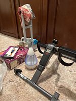 Photo showing metal foot pedal exerciser, HoMedics mini humidifier, cloth neck wrap and a boxed item likely Dr. Ho muscle therapy device