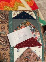 Close-up of folded pillow with multicolored floral and paisley patchwork fabric