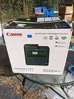 Front and side view of the Canon imageCLASS MF236n printer original packaging box with product image and features.