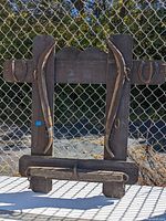 Full view of the primitive decorative coat rack showing wooden planks, horseshoes on each side, and wooden pegs for hanging