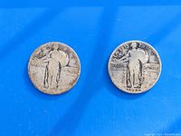 Two vintage Standing Liberty quarters on a blue background, showing full obverse design and visible dates.
