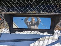 Frontal view of decorative mirror with shelf, showing rectangular mirror and slatted wooden shelf below within a dark finish frame.