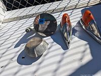 Vintage car parts including two side mirrors, two orange turn signal covers, and a chrome grille part.