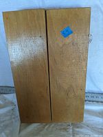 Closed wooden foldable case from back showing plain wood finish with small blue price tag