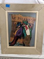 Front view of framed mixed media artwork depicting two colorful figures and a newspaper background.