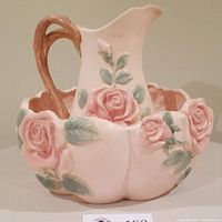 Front view of pink rose ceramic pitcher inside matching wash basin with floral details