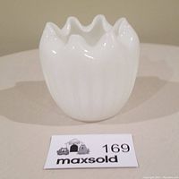 Front view of small white milk glass planter showing scalloped rim and vertical ridges.