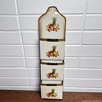 Front view of vintage tin wall pocket letter sorter with fruit motif lithograph and labeled pockets
