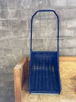 Blue push snow shovel angled to show front and side profile with clear plastic blade and metal handle.