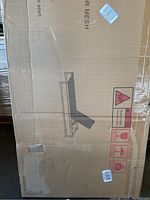 Box showing printed outline of the sun bathing chair, featuring a reclined lounge chair design with a supporting frame underneath.