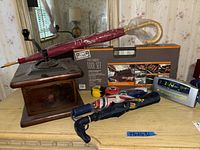 Overview showing coffee grinder, umbrellas, grilling tool set box, and digital clock on dresser