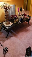 Full view of the dark wood coffee table/bench with various decorative items on top, showcasing its overall design and condition
