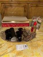 Lot overview showing Estée Lauder makeup set, sunglasses, mirrored tray, perfume bottle, and floral packaging