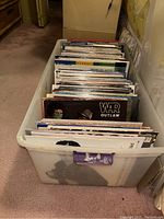 Photo of white plastic tote full of vinyl records showing the quantity and general condition of the lot