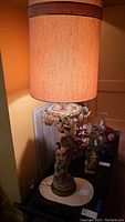 Full view photo of the tall vintage figural lamp with floral and grape light details