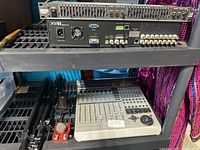 Top view showing Rane graphic equalizer and rear connections with blue VGA output and multiple BNC connectors, above Mackie digital mixer and some accessories below shelf