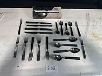 Flatware spread out on table with original box in the background, showing full contents.