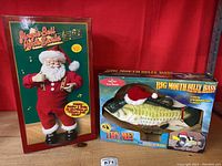 Front view showing Jingle Bell Rock Santa in red outfit and Big Mouth Billy Bass in Santa hat in original boxes