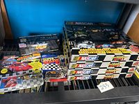 Full overview of the complete lot showing the packaging and toy cars arranged on a shelf.