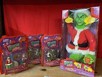 Photo showing the full lot of four boxed Grinch toys including the large Transforming Talking Grinch and three smaller character figure sets.
