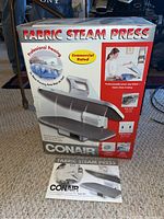 Box and manual for Conair Fabric Steam Press model FSPS5 showing product image and features on packaging.