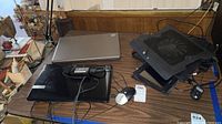 Four laptops including Gateway, Pandigital tablet, two HP models, and two black laptop cooling fans on a wooden table