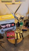 Full view of the lot on a small round table showing watches, boxed gift set, wallets, bracelet, and tissues.
