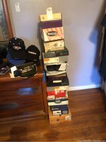 Stack of 11 shoe boxes from various brands including Rico, Hush Puppies, Dr. Scholls, Mecha, and High Test.