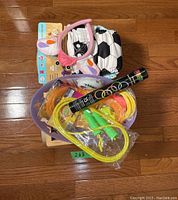 Photo showing letter and numbers cube toy, pink and white kids hair bands, soccer ball printed reusable diaper, multi-colored kids socks, and a purple basket containing colorful jump ropes and hula hoops.
