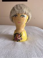 Front view of the real fur ladies hat on the wooden model head showing the full shape and fur texture.