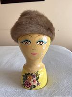 Front view of the mink ladies hat displayed on a painted mannequin head showing the hat's rounded natural brown fur design and soft texture.
