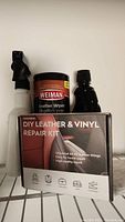 Photo showing the repair kit box with repair kit items in background including spray bottle, Weiman leather wipes, and small bottle.